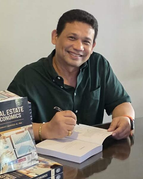 Dr. Dan Marcelo signing copies of his book Real Estate Economics